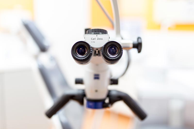 photograph of the eyepiece of a microscope in front of a dental chair